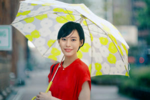 南沙良(みなみ・さら)。雨傘・ピオニ(イエロー)と赤いワンピースの組み合わせ。CMモデル
